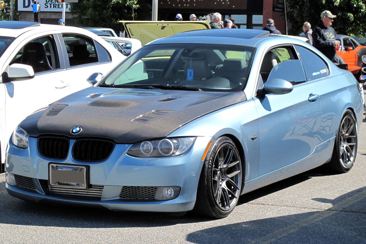 2008 BMW E92 335i coupe in Atlantic Blue metallic photographed from front left on factory OEM wheels