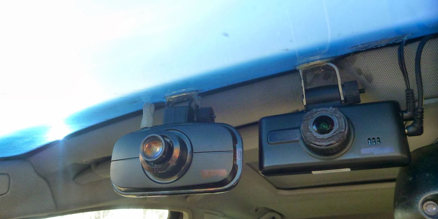 Close-up of a dashcam device showing the lens on the front and the rear playback screen