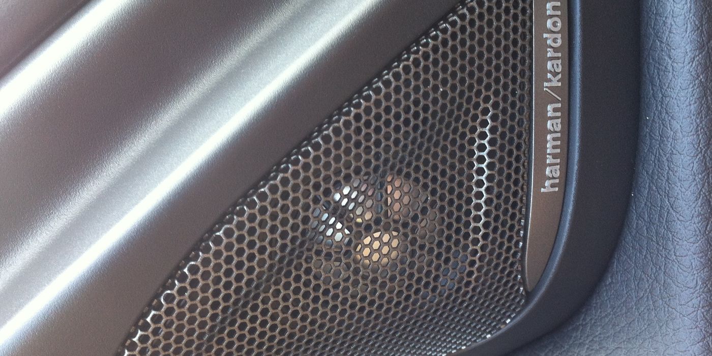 Close-up of a car component speaker woofer with its separate tweeter and crossover network laid out