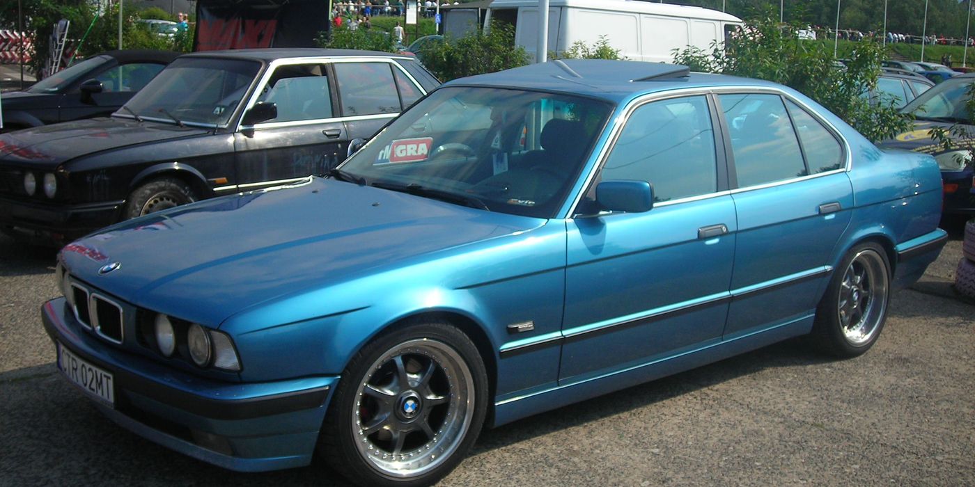 BMW sedan elevated on a workshop two-post lift exposing the underbody