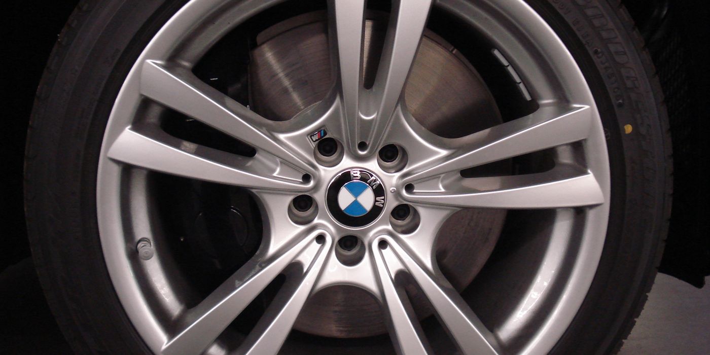 Vented brake rotor visible through BMW alloy wheel spokes showing caliper and disc face