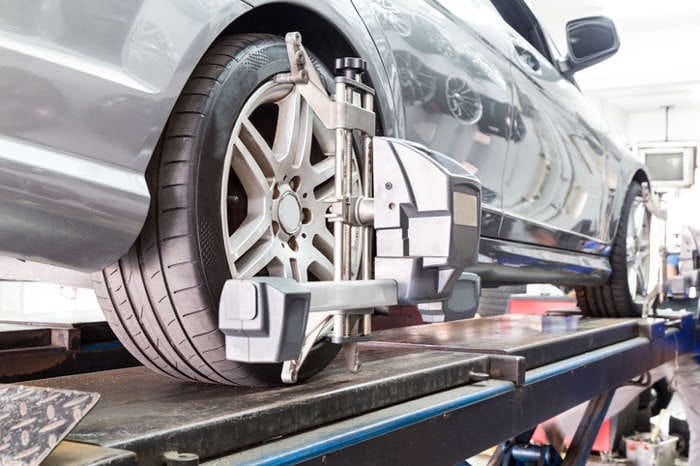 BMW with coilovers on alignment rack with corner weight scales