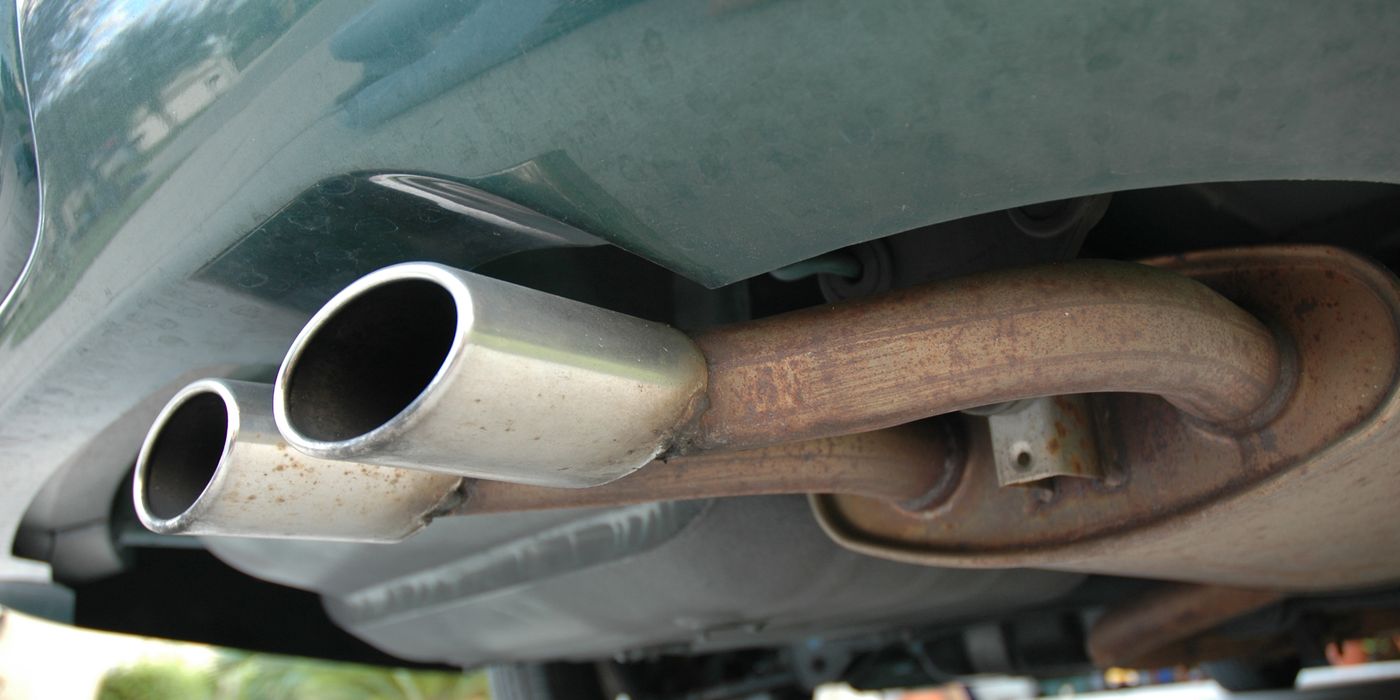 Close-up of polished stainless steel exhaust pipe and muffler section