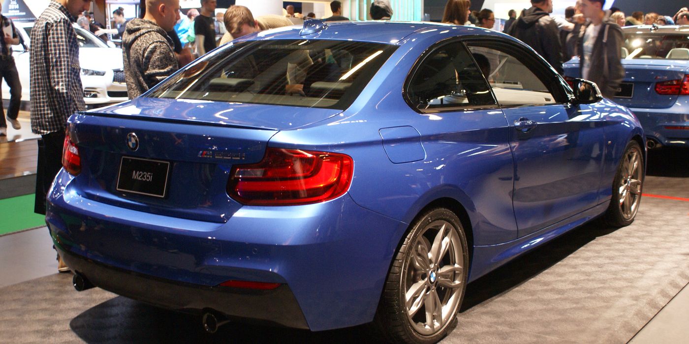 Blue BMW M235i F22 coupe rear three-quarter view showing exhaust tips and diffuser