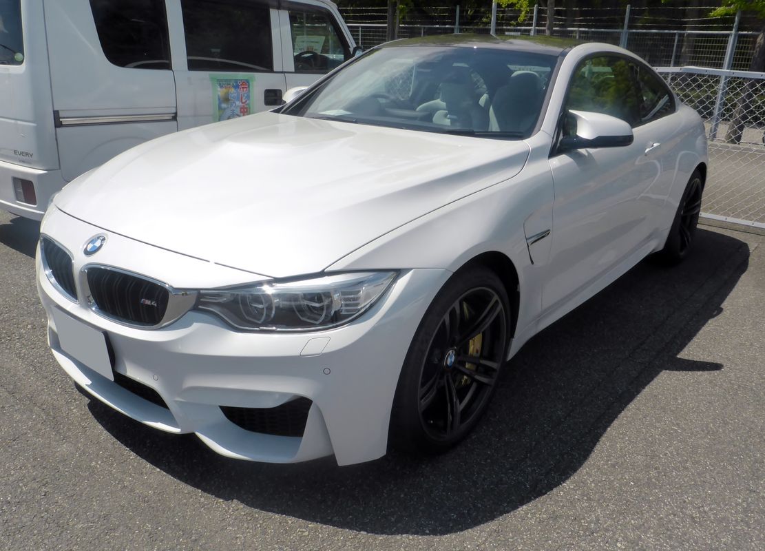 BMW M4 F82 coupe front view on factory double-spoke M forged wheels showing the stock 666M-style fitment