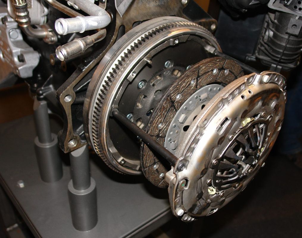 Automotive clutch cover and friction disc mounted to flywheel, view looking into the bellhousing with transmission removed