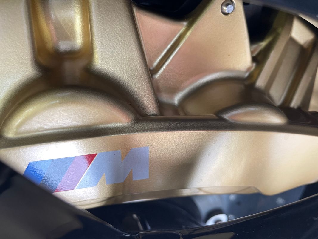 Close-up of BMW M4 G82 front wheel, brake disc and M-branded caliper showing wheel fitment and brake clearance