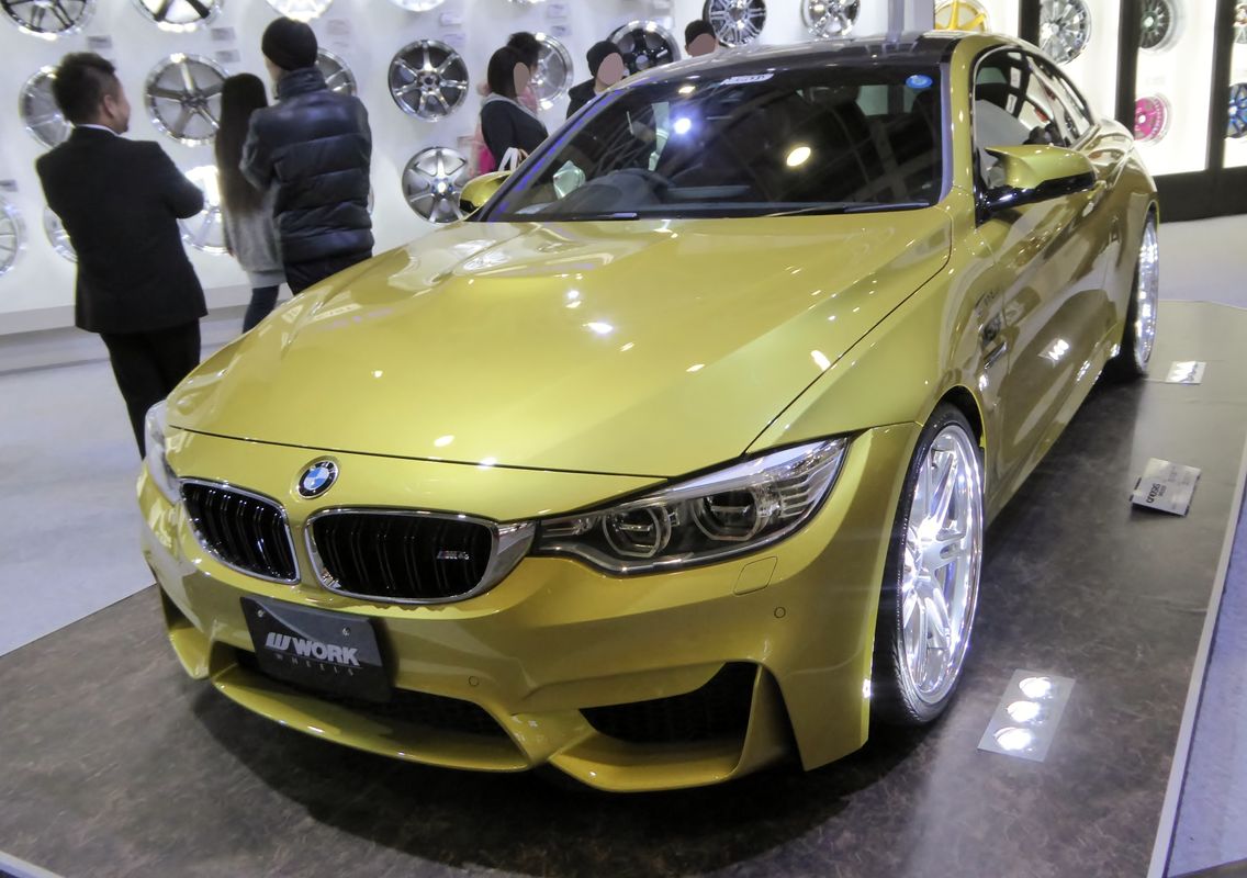 BMW M4 F82 coupe fitted with aftermarket WORK forged wheels at Osaka Auto Messe 2015, demonstrating tuner wheel upgrade